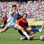 HNnxz0UW0AA1Lj8 | The Soccer Goal Two soccer players compete for the ball during a match; one wears a light-blue/white Argentina kit and the other a red/blue jersey, with a full stadium in the background.